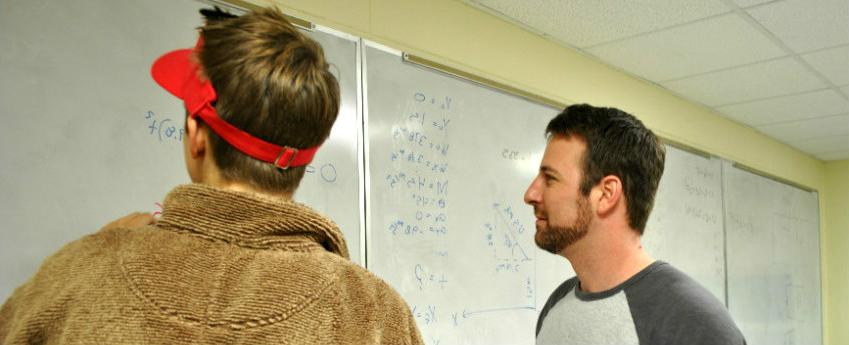 两个学生在白板上计算物理方程.