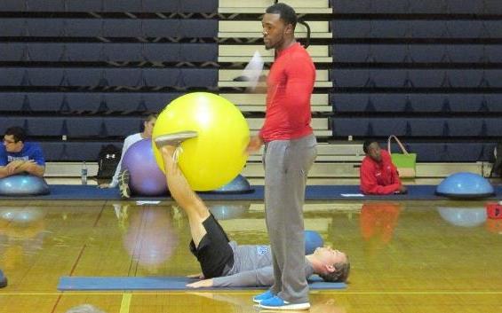 Male student coaching an exercise class.