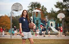 女学生在球场前拿着篮球.